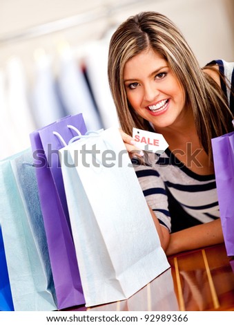 Happy shopping woman holding a sale tag