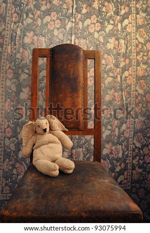 knitted bunny sitting on an old chair with background