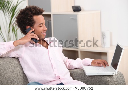 Man sat with laptop and telephone at home