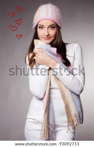 beautiful woman in warm clothing on gray background