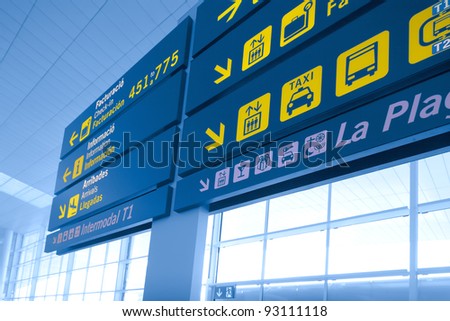 A navigation board at airport, a view from small angle, yellow signs on blue board
