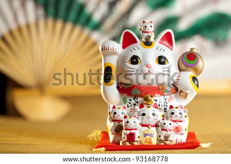 Maneki Neko cat. Common Japanese sculpture bring good luck to the owner. Royalty-Free Stock Photo #93168778