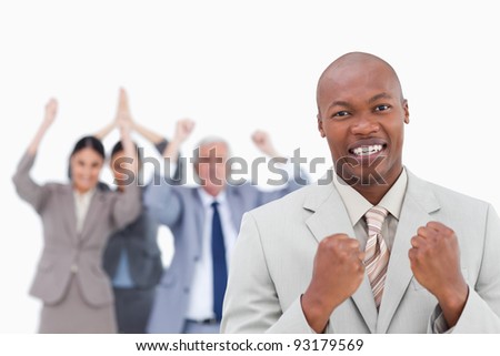 Successful businessman with cheering team behind him against a white background