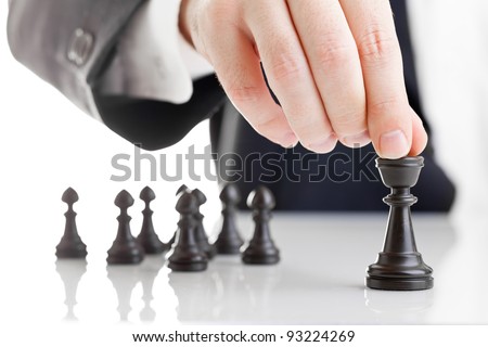 Business man moving chess figure with team behind - strategy, management or leadership concept