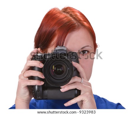 Portrait of a redheaded girl taking photos with a DSRL camera.