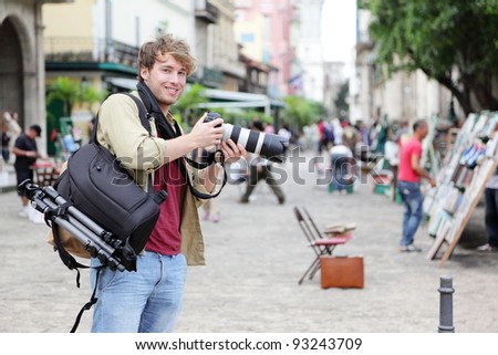 Travel photographer, Havana, Cuba on Plaza de Armas in Old Havana with Camera equipment taking pictures.