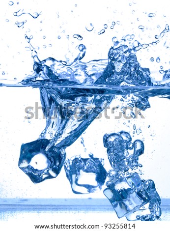 ice cubes dropped into water with splash on white