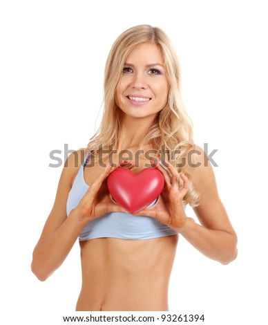 Beautiful fitness girl and red heart isolated on white