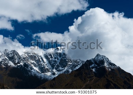 Snowed up mountain range and clouds in Himalayas. Pictured in Nepal