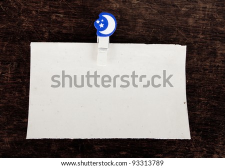 close up of an old paper and clothes peg on a wooden background