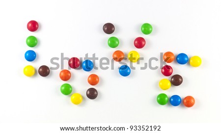 Title LOVE of colored candies on white background