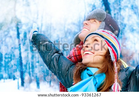 Happy Young Couple in Winter Park having fun.Family Outdoors