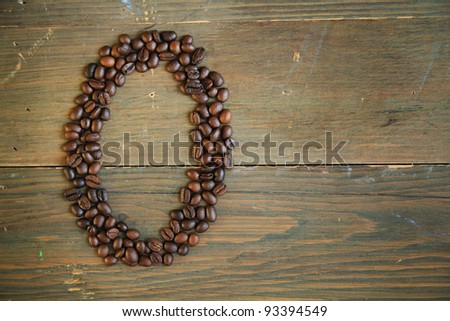 Number zero made with coffee beans on a wooden plank