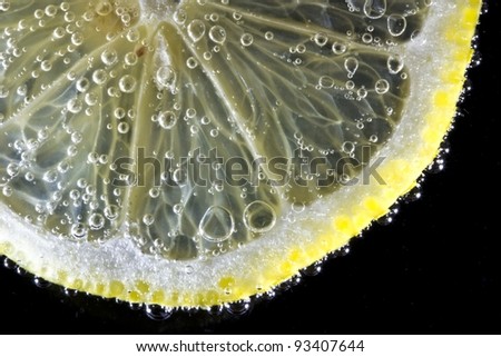 Thin slice of yellow lemon in soda water to form the bubbles