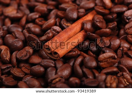 macro photo of cinnamon sticks over coffee beans background/Cinnamon with coffee beans