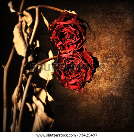 Grunge wilted roses over abstract dark old wallpaper background, floral red border with dried out flowers, retro vintage style photo, death concept