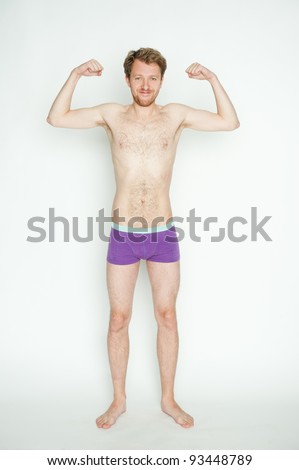 Slim or skinny young man in underpants flexing muscles, isolated on white background Royalty-Free Stock Photo #93448789