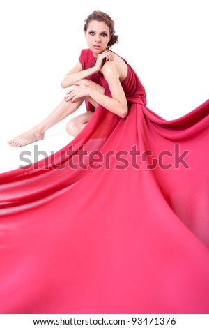 Seated beautiful woman in a red dress on white background