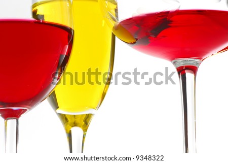 Three wine glasses filed with wine red and white on white background