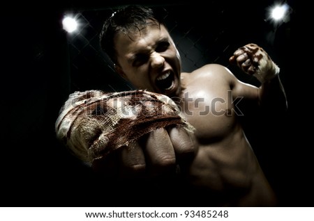horizontal photo  muscular young  guy street-fighter, cuff  fist close up on camera and yell , hard light