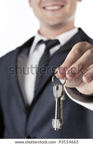 Businessman with a house key in hand isolated on white