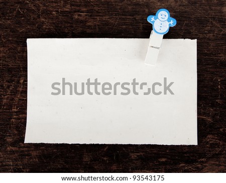 close up of an old paper and clothes peg on a wooden background