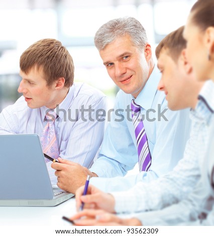 Happy business team talking together during a meeting sitting at a table