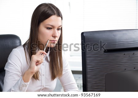 Attractive young caucasian brunette businesswoman sitting in her office