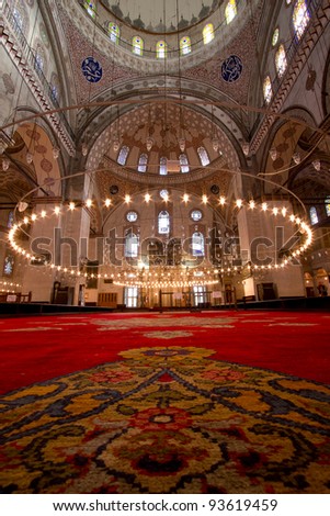 Inside Istanbul Mosque with red carpet in foreground . Picture with a lot of mosque details and big columns