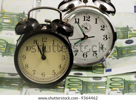 Two alarm clocks on euro banknotes