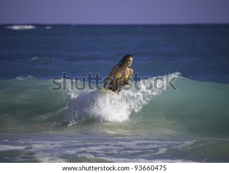 young woman surfing in hawaii