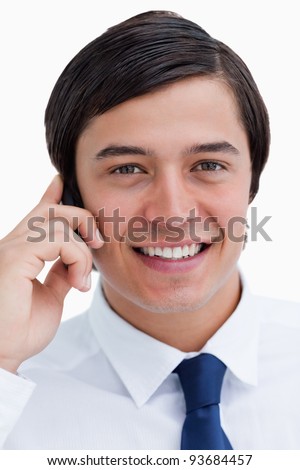 Close up of smiling tradesman on his mobile phone against a white background