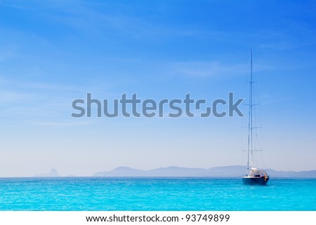 Ibiza mountains with sailboat from Formentera turquoise sea