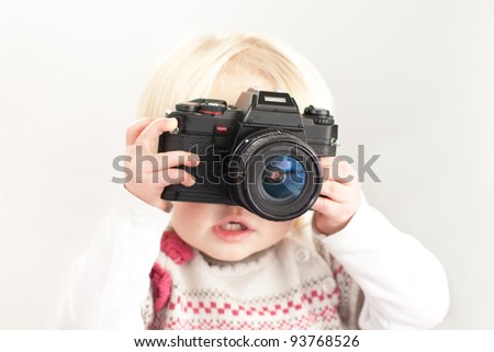Child holding a camera taking a picture