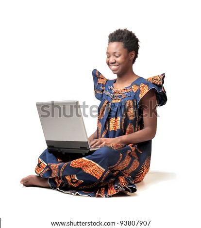 Smiling african woman in traditional clothes using a laptop
