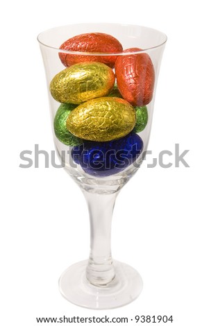 Goblet filled with easter eggs on white background