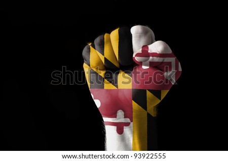 Low key picture of a fist painted in colors of american state flag of maryland