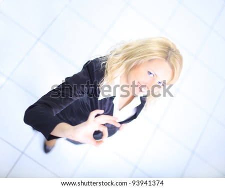 Positive business woman smiling and making ok sign in her office