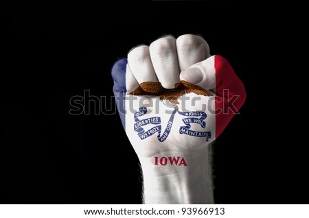 Low key picture of a fist painted in colors of american state flag of iowa