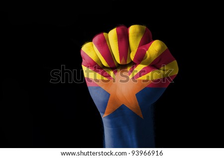 Low key picture of a fist painted in colors of american state flag of wyoming