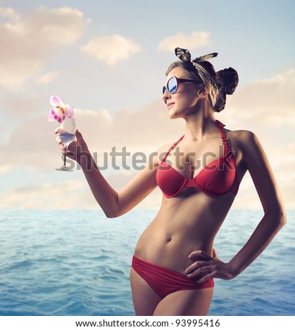 Beautiful woman at the seaside holding a drink