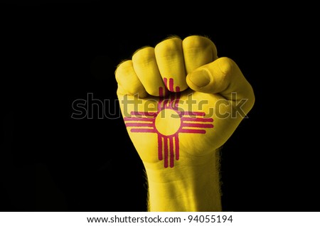 Low key picture of a fist painted in colors of american state flag of new mexico
