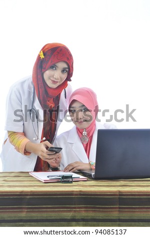 two beautiful muslim medical doctor woman with stylish scarf using phone isolated on white background