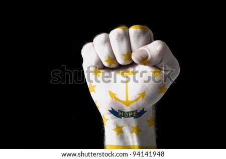 Low key picture of a fist painted in colors of american state flag of rhode island