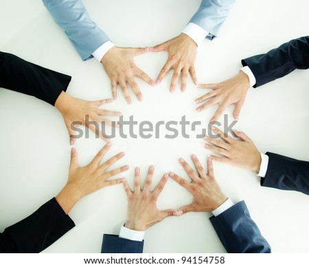 Top view of businesspeople holding hands together on a plain white surface