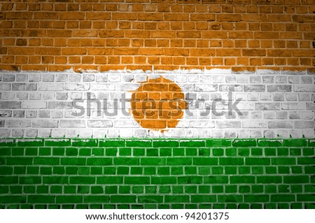 An image of the Niger flag painted on a brick wall in an urban location