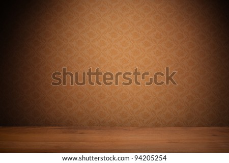 Vintage textured brown wallpaper with heavy vignetting over a wooden floor, empty with copyspace.