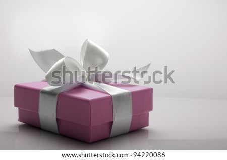 small pink box tied with a white ribbon Royalty-Free Stock Photo #94220086