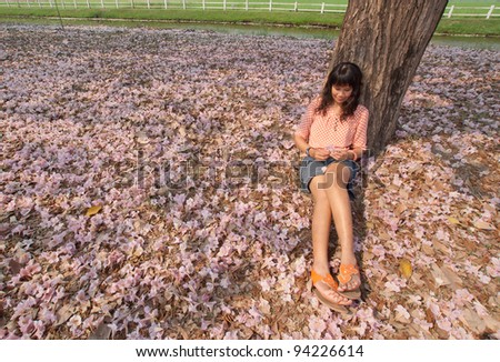 Young woman relaxing on carpet of pink flower