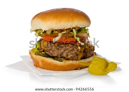 Homemade chili burger with cheddar cheese against a white background.